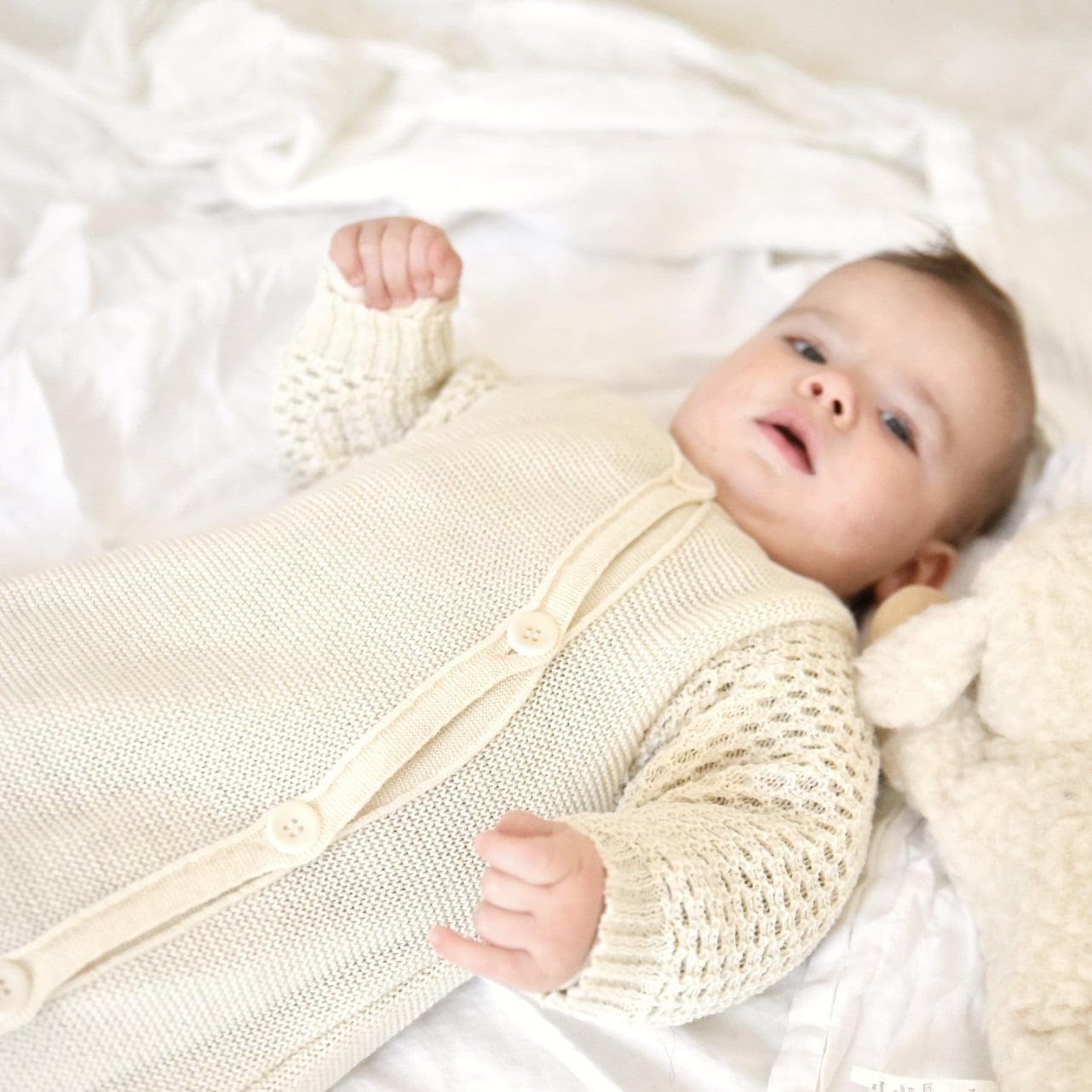 Brassière bébé ecru en laine mérinos tricotée